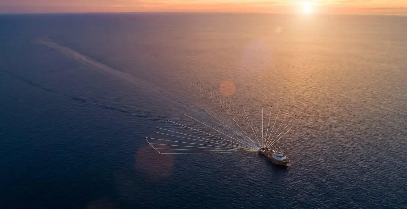 Vue aérienne d'un navire sismique en opération offshore avec équipements d'acquisition de données géophysiques